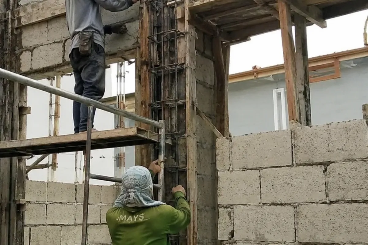 Reinforced concrete stiffener column being formed within a concrete hollow block wall