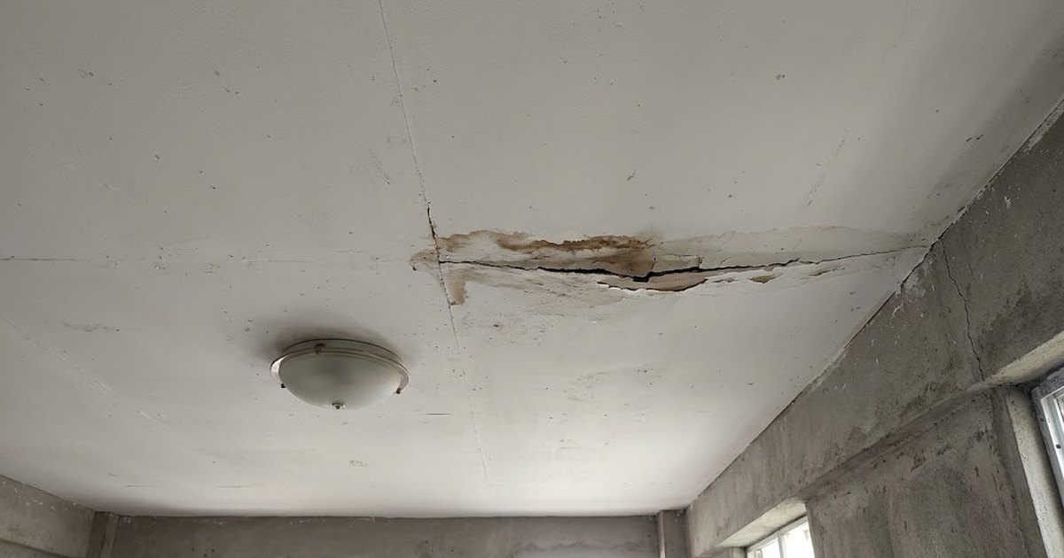 Water-stained gypsum board ceiling with a cracked joint in a Philippine house