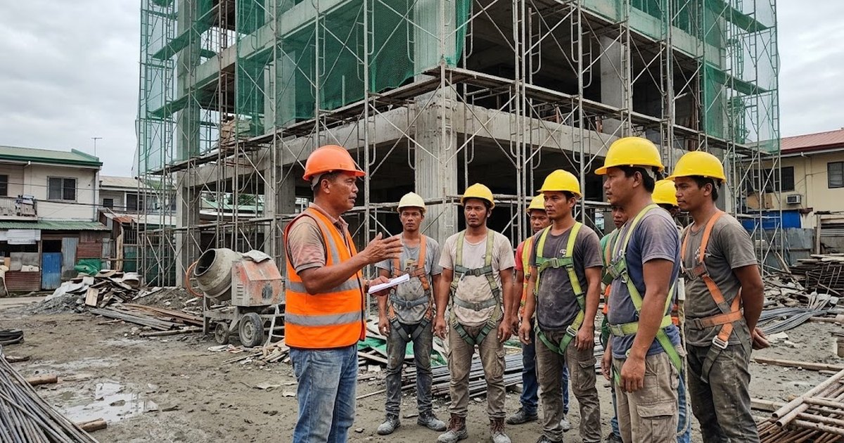 Safety officer briefing a construction crew in hard hats on a mid-rise building site