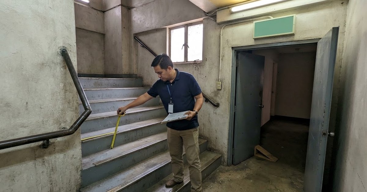 Enclosed fire exit stairway with handrails in a commercial building
