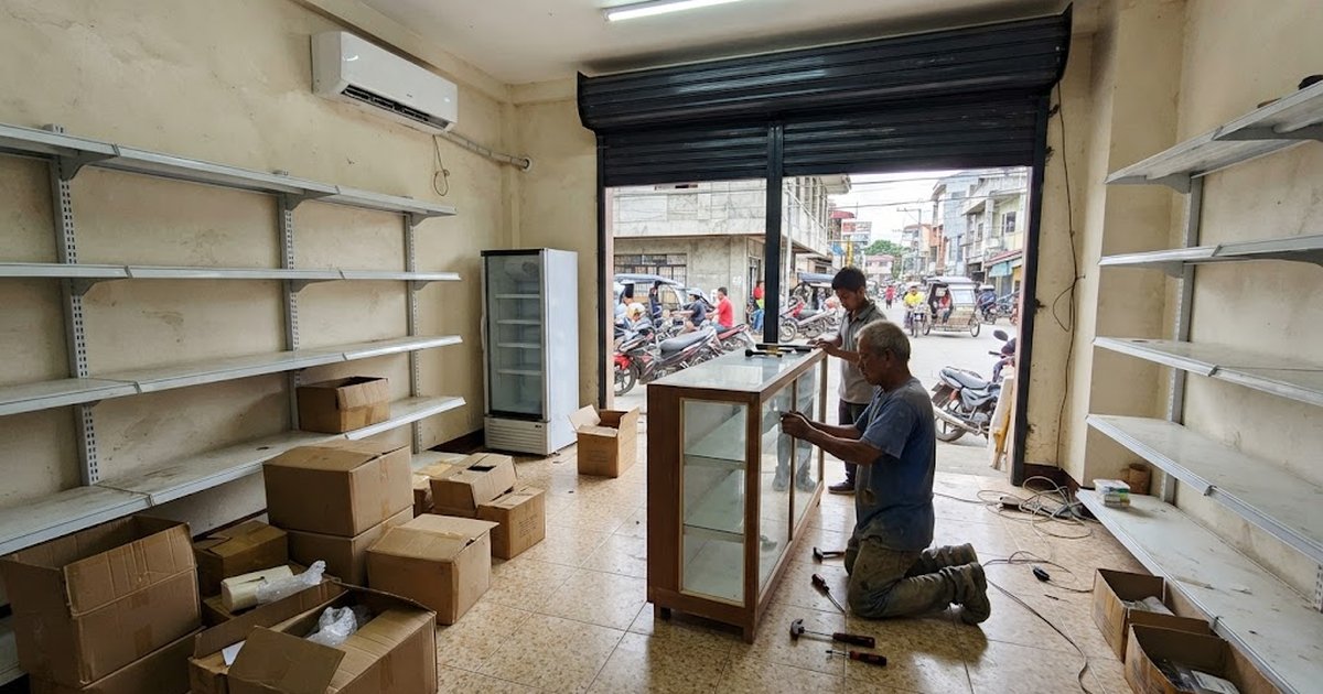 Carpenters installing a dispensing counter in a small drugstore