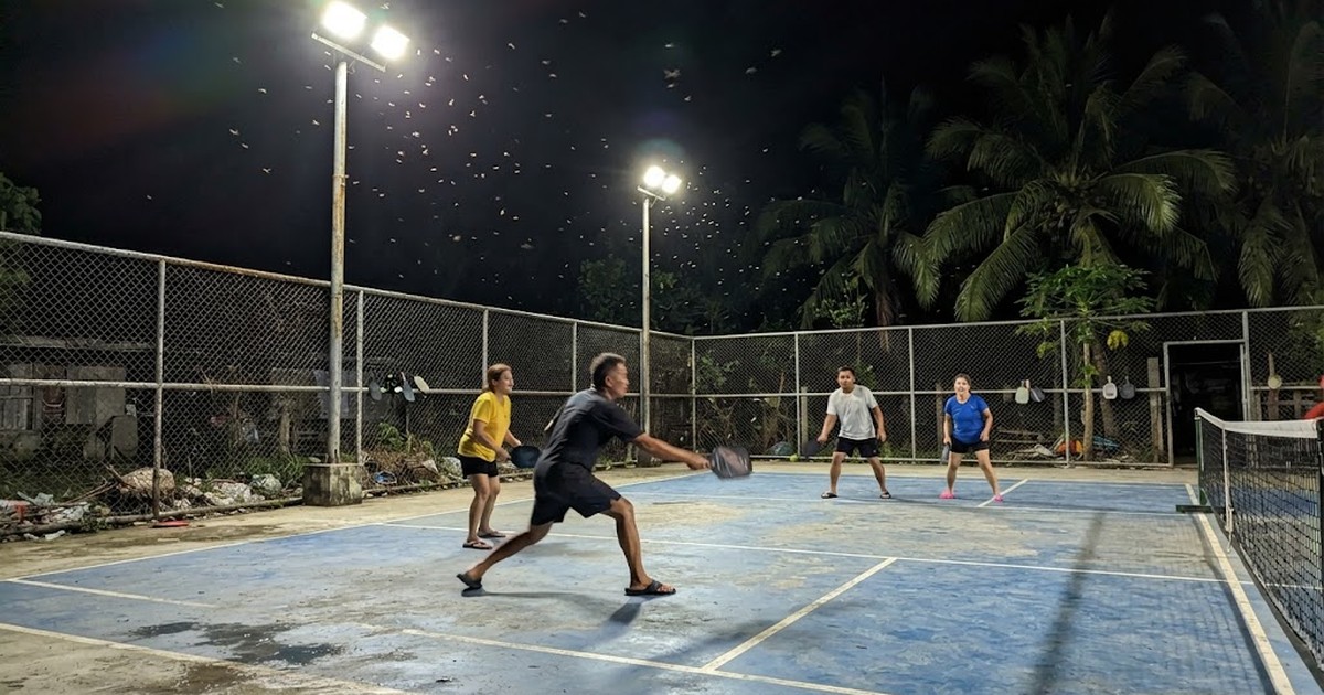 LED floodlights on tall poles lighting an outdoor pickleball court at night in the Philippines