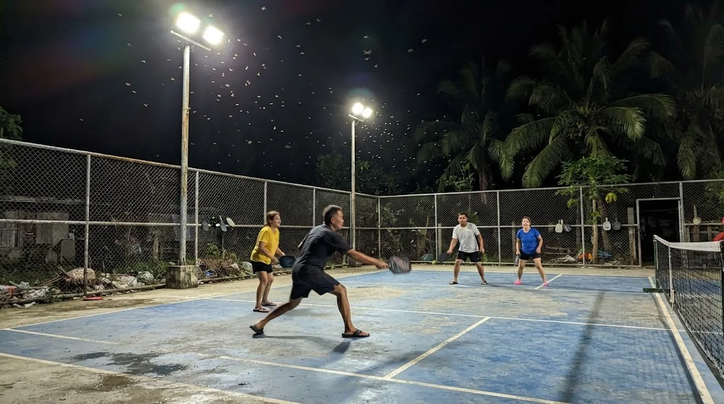 LED floodlights on tall poles lighting an outdoor pickleball court at night in the Philippines