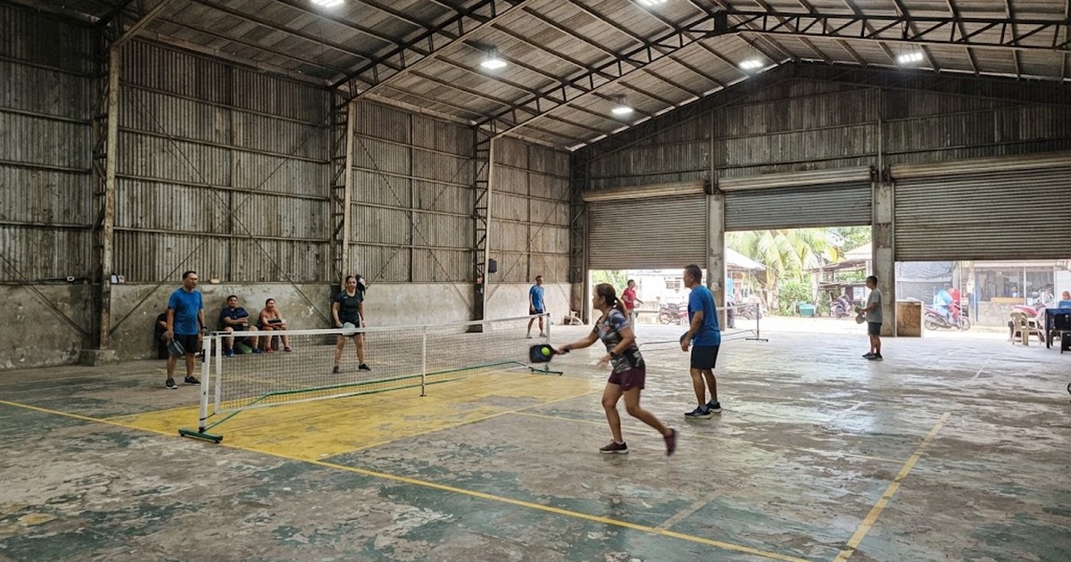 Indoor pickleball courts inside a steel-frame warehouse-style hall in the Philippines with bright ceiling lighting