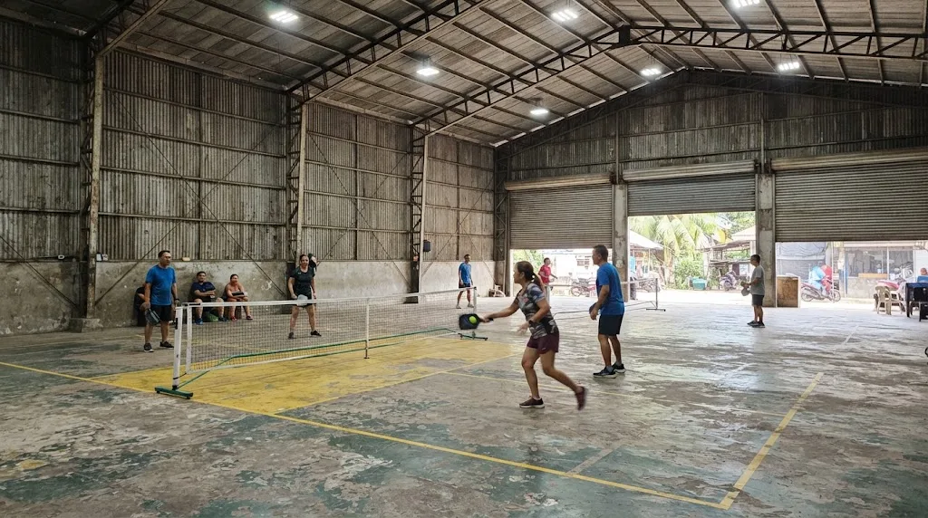 Indoor pickleball courts inside a steel-frame warehouse-style hall in the Philippines with bright ceiling lighting