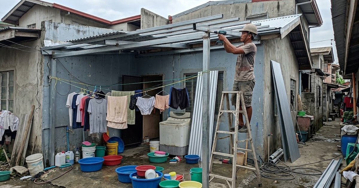Steel frame roof extension with metal roofing over a Filipino home's side yard laundry area, worker fixing purlins