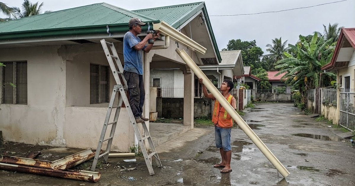 Workers installing a new roof gutter on a Filipino house
