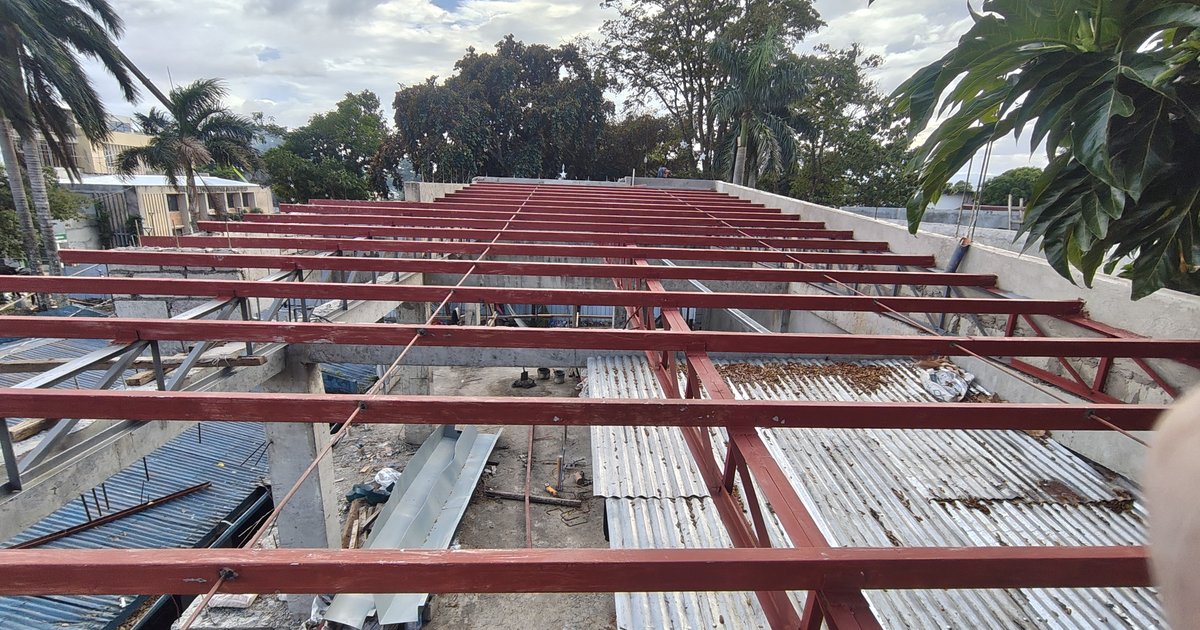 Metal roofing on a Philippine house being secured against typhoon uplift