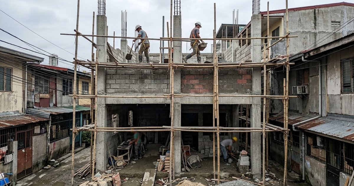 Three-storey concrete house under construction on a narrow Philippine city lot with scaffolding and CHB walls