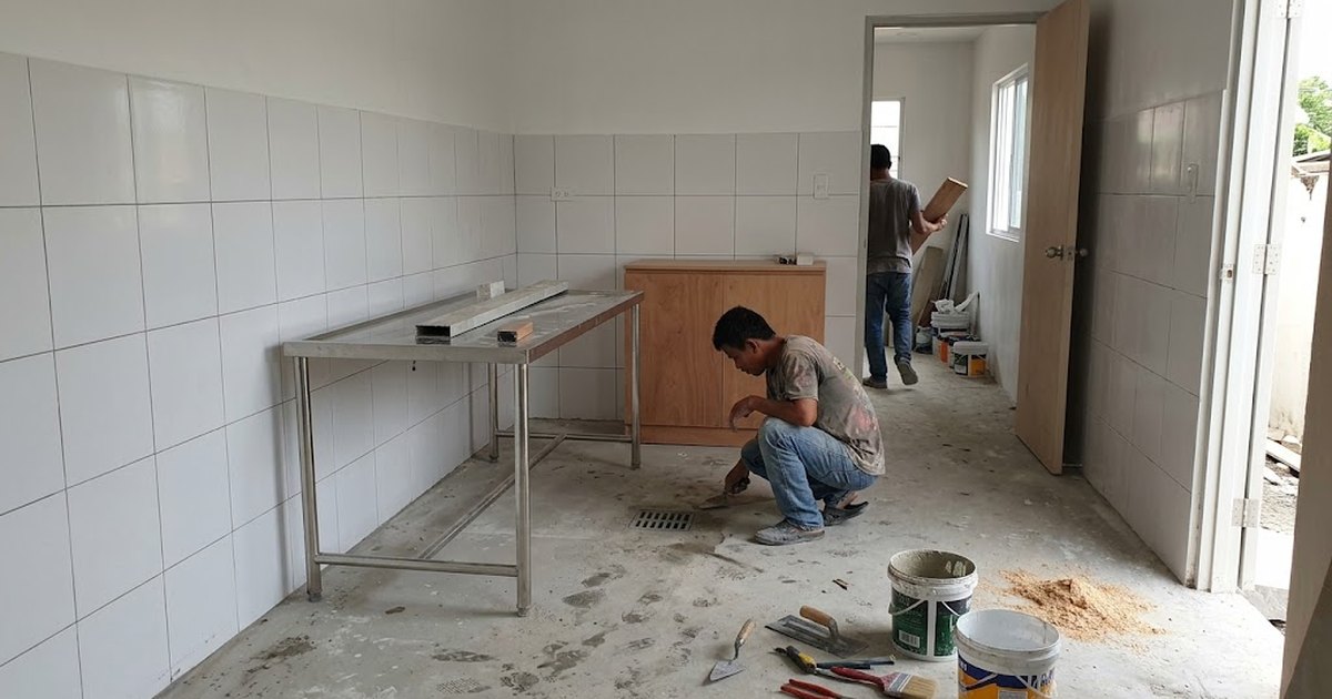Small veterinary clinic consultation room under construction in the Philippines with stainless exam table, washable wall tiles and floor drain
