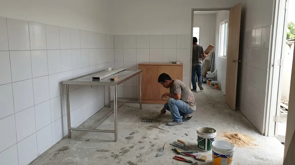 Small veterinary clinic consultation room under construction in the Philippines with stainless exam table, washable wall tiles and floor drain