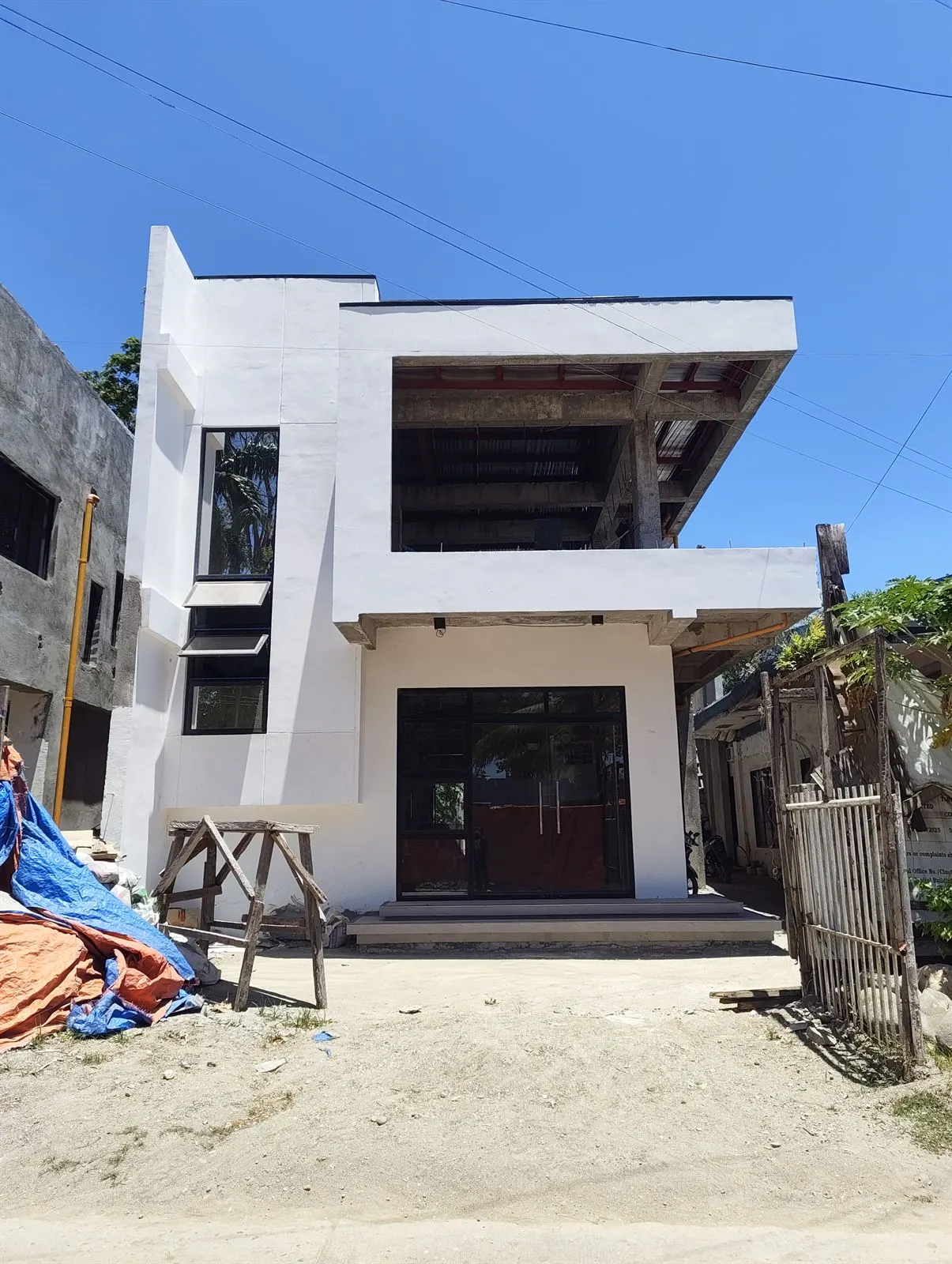 Two-storey building in late-stage exterior finishing works — the stage where occupancy permit preparation should start